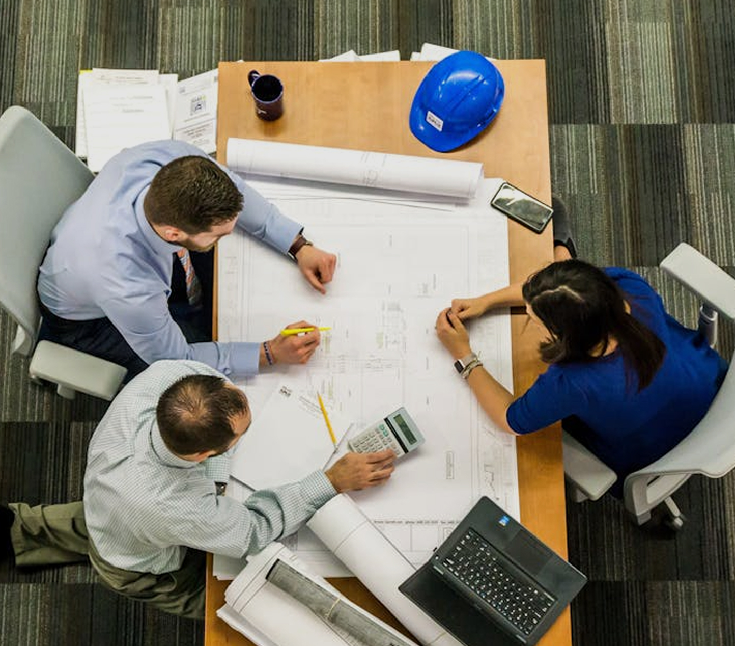 Team reviewing building plans around a table